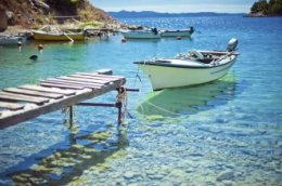 Лодка, пришвартованная к пирсу, в прозрачной морской воде у берегов Кипра